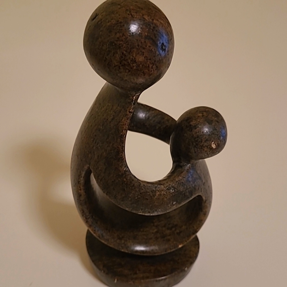 Distressed statue of parent & child